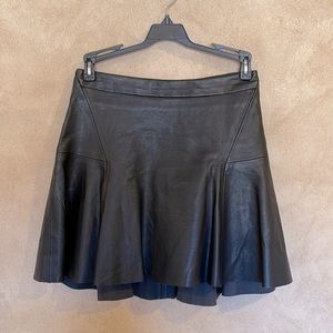 Black faux leather mini skirt with gold zippers in back.  New without tags.